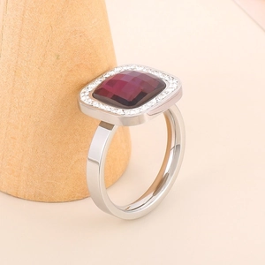 Macro shot of silver ring with square purple stone and pavé crystal border details
