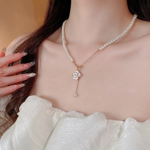 Detailed view of the camellia pearl necklace on model showing elegant craftsmanship