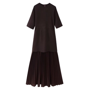 Detail of dark brown short sleeve knit dress featuring pleated skirt and round neck
