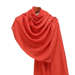 Red cotton linen long scarf on wooden hanger, solid soft shawl for spring and summer