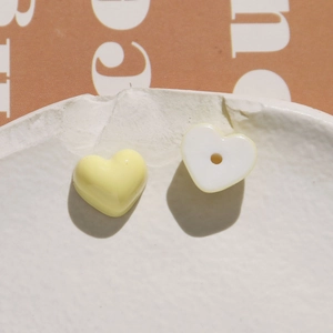 Detailed macro view of heart-shaped resin beads in yellow and white for DIY crafts