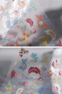 Macro detail of floral and feather nail art stickers with delicate gold stamping texture