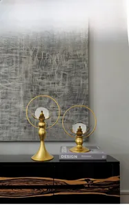 Close-up of dual golden lotus crystal ball ornaments on a modern wooden sideboard