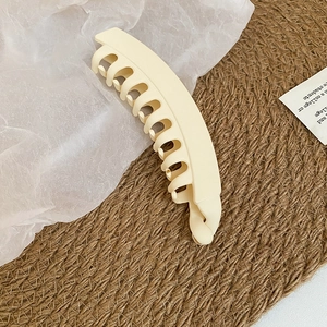 Vue détaillée de la texture mate et des dents de la barrette banane en acrylique crème
