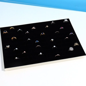 Detail view of 100-slot black velvet jewelry display tray for rings and ear studs