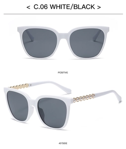 Detail of square white frame sunglasses featuring decorative gold and pearl chain temples