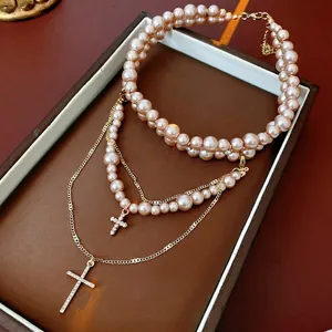 Double-layered pearl necklace with diamond cross pendants in vintage gold finish
