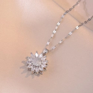 Silver rotating sunflower necklace with marquise zircon petals on beige fabric