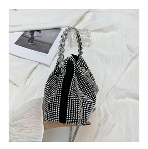 Detail of black rhinestone bucket bag with sparkling handle and metal chain strap