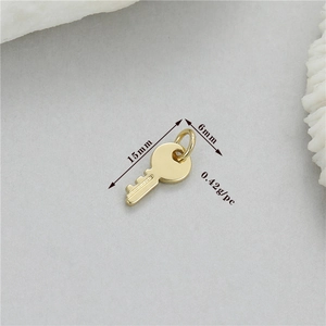 Macro detail of 14K gold plated key pendant showing 15mm length and 0.42g weight spec