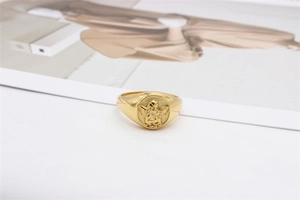 Macro shot of gold-plated signet ring featuring a vintage cupid angel relief design