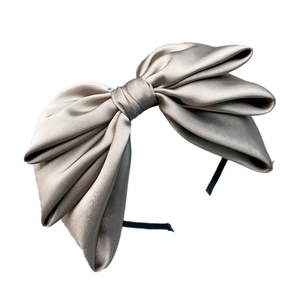 Elegant champagne satin headband featuring an oversized triple-layered bow design