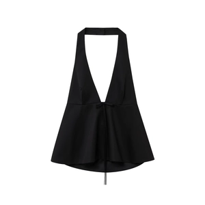 Détail d'un haut dos nu noir avec col en V profond et ourlet péplum sur fond blanc