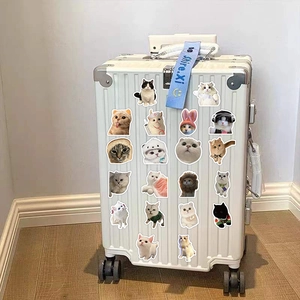 White suitcase decorated with various cute realistic cat stickers and a blue handle strap