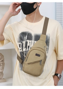 Detail view of khaki canvas crossbody bag with SPORT badge and earphone port