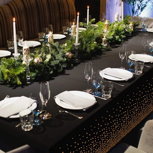 Elegant table setting featuring black and rose gold polka dot runner with festive decor