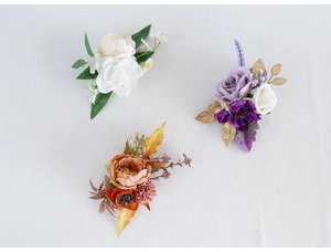 Detail of handmade bridal wrist corsages with realistic roses in three color schemes