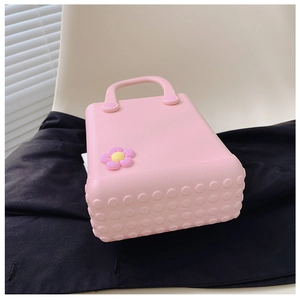 Makroaufnahme der rosa EVA-Strandtasche mit rutschfester Textur und lila Gänseblümchen