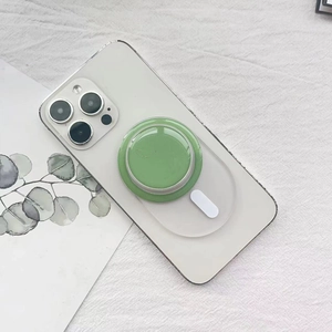 Dettaglio custodia bianca con supporto MagSafe verde magnetico su sfondo di lino bianco