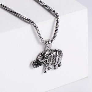 Macro shot of retro elephant pendant featuring 18K gold plating and detailed engraving