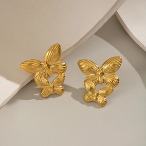 Textured 18K gold butterfly stud earrings on a minimalist geometric background