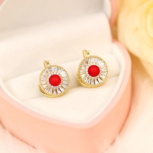 Detail of red pearl gold earrings with baguette zircon in heart gift box