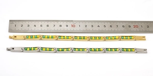 Detailed view of 18K stainless steel bead bracelets in gold and silver with a ruler