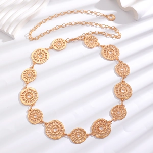 Detail of vintage gold metal waist chain with hollow medallions and adjustable links
