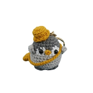 Handmade crochet penguin keychain with grey body, yellow hat, and metal ring clasp