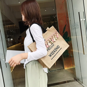 Minimalist jute tote bag with Hello Weekend print and colorful tassel accents for women