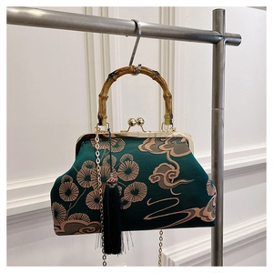 Detail der dunkelgrünen Seidensticktasche mit Bambusgriff und goldener Quasten-Deko