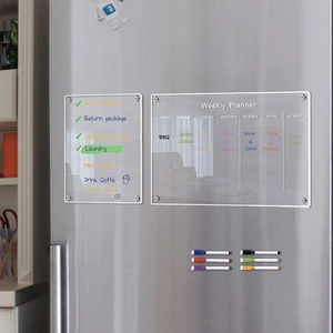 Macro shot of magnetic acrylic weekly planner and checklist on stainless steel fridge