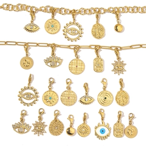 Detailed close-up of golden Evil Eye charms with zircon inlays and lobster clasps