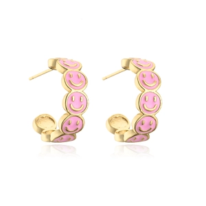 Detail shot of 18K gold plated C-shaped earrings with cute pink enamel smiley faces