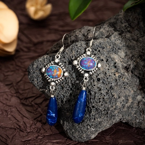 Detailed close-up of Bohemian drop earrings with blue lapis lazuli and silver metal engraving