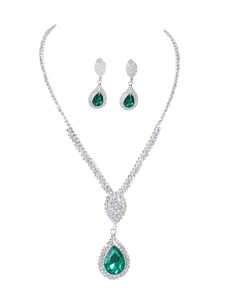 Detailed view of luxury emerald green teardrop necklace and silver rhinestone earrings set