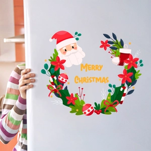 Detail of Christmas wall stickers featuring Santa and wreaths on a white fridge surface