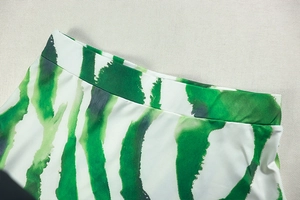 Close-up of green and white abstract print dress showing high-quality waist stitching