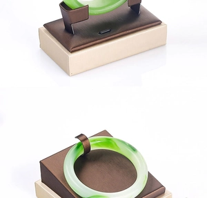 Detail view of a translucent green jade bangle on a premium display stand for jewelry storage