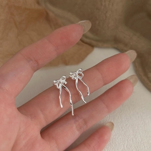 925 silver bow stud earrings with asymmetric long flowing tassels in a minimalist style