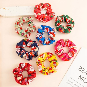 Flat lay of colorful Christmas scrunchies featuring festive Santa and reindeer patterns