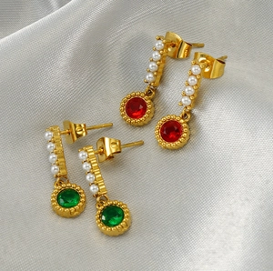 Detailed macro view of vintage emerald and pearl earrings with 18K gold plated finish