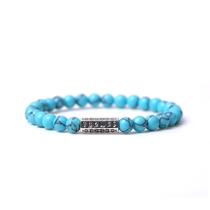 Détail de perles de pierre naturelle bleu ciel de 8mm et breloques argentées sur le bracelet