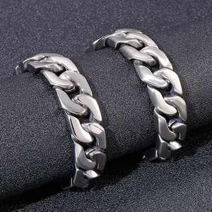 Polished and brushed stainless steel Cuban link bracelets for men on black display stand