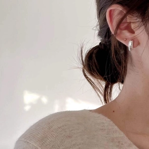 Elegant 925 sterling silver V-shaped earrings worn by a model in soft lighting