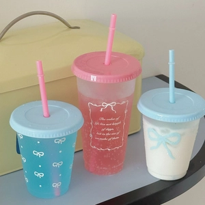 Detailed view of colorful plastic straw cups in blue, pink, and white with bows