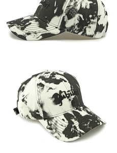 Détail d'une casquette tie-dye avec broderie 3D noire du texte jubilant devant