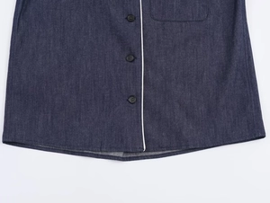 Detailed macro view of navy blue denim shirt with white trim and single-breasted buttons