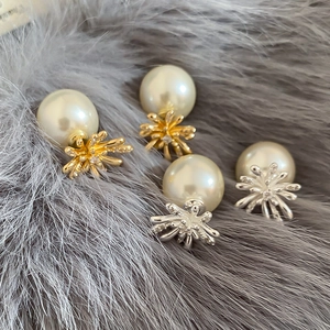 Macro detail of gold and silver plated fireworks earrings with pearls and crystals