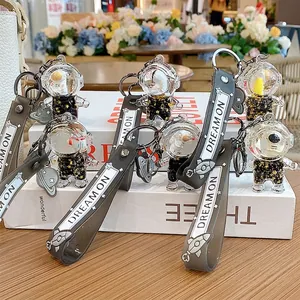 Astronaut liquid bottle keychain with black gold space theme and Dream On silicone strap